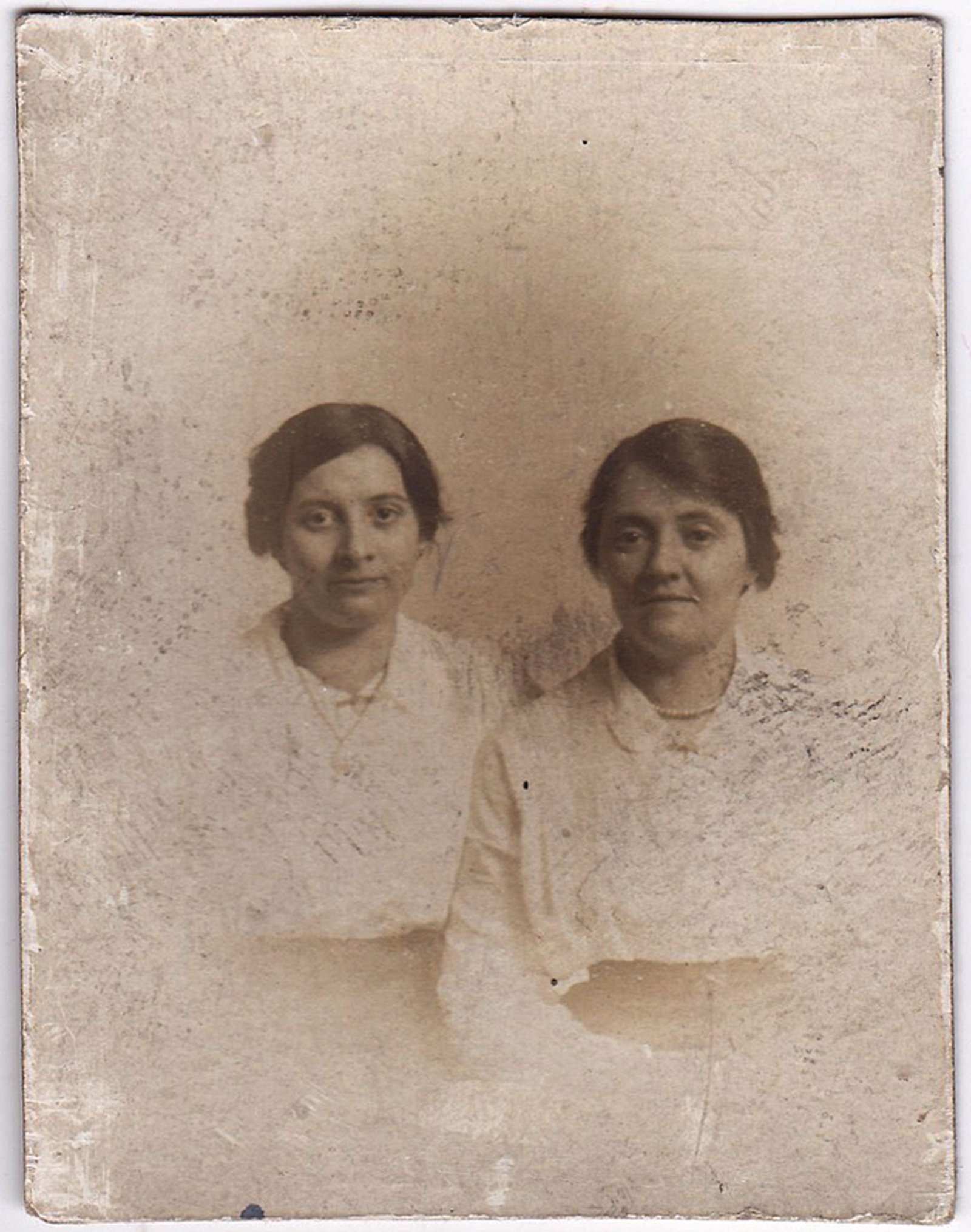 Damaged vintage photograph of two women before restoration